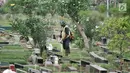 Petugas kebersihan memotong rumput makam di TPU Karet Bivak, Jakarta, Kamis (12/7). Data Dinas Kehutanan DKI mencatat dari 611,59 hektare lahan makam yang sudah dibebaskan, 60 persen atau 365,13 hektare sudah dipakai. (Merdeka.com/Iqbal Nugroho)