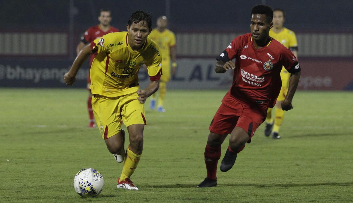 Gelandang Bhayangkara FC, Adam Alis, berebut bola dengan pemain Semen Padang pada laga Shopee Liga 1 di Stadion PTIK, Jakarta, Sabtu (2/11). Bhayangkara bermain imbang 2-2 atas Semen Padang. (Bola.com/Yoppy Renato)