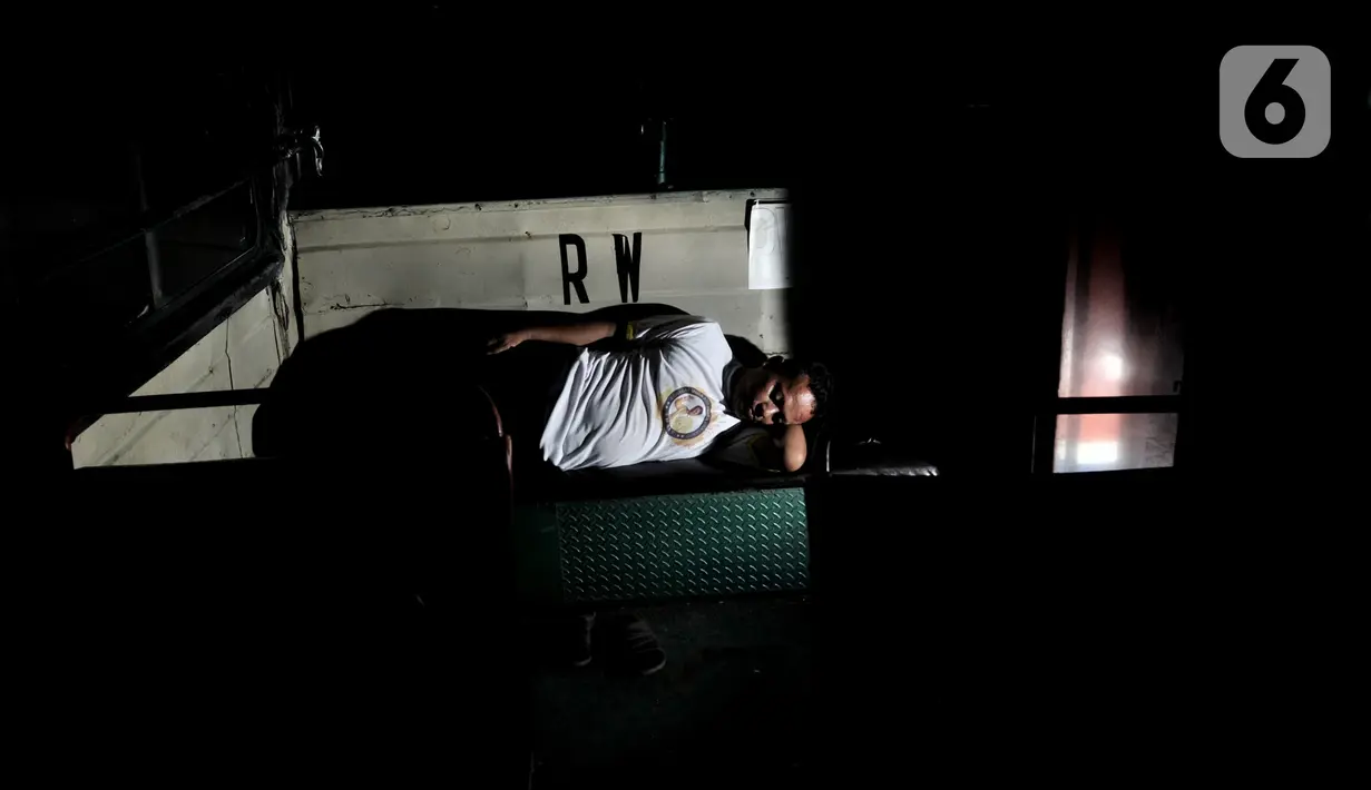 Maruli (43) sopir Metromini tidur di dalam bus saat menginap di pool. Karya foto ini sedang dipamerkan dalam pameran foto dengan tema ”Innovation” di Erasmus Huis. (merdeka.com/Iqbal S Nugroho)