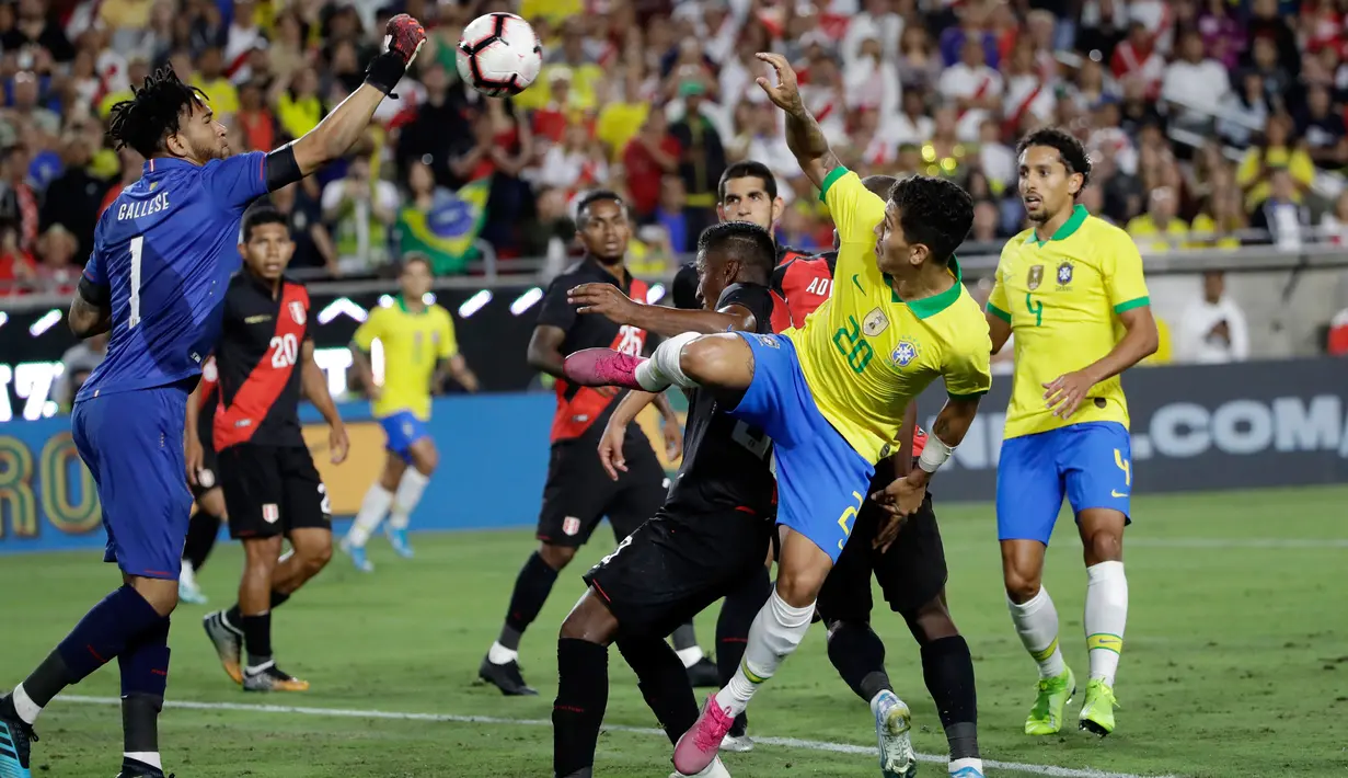 Kiper Peru Pedro Gallese (kiri) meninju bola saat menghadapi Brasil dalam laga persahabatan di Los Angeles Memorial Coliseum, California, Amerika Serikat, Selasa (10/9/2019). Peru menang 1-0 atas Brasil. (AP Photo/Marcio Jose Sanchez)