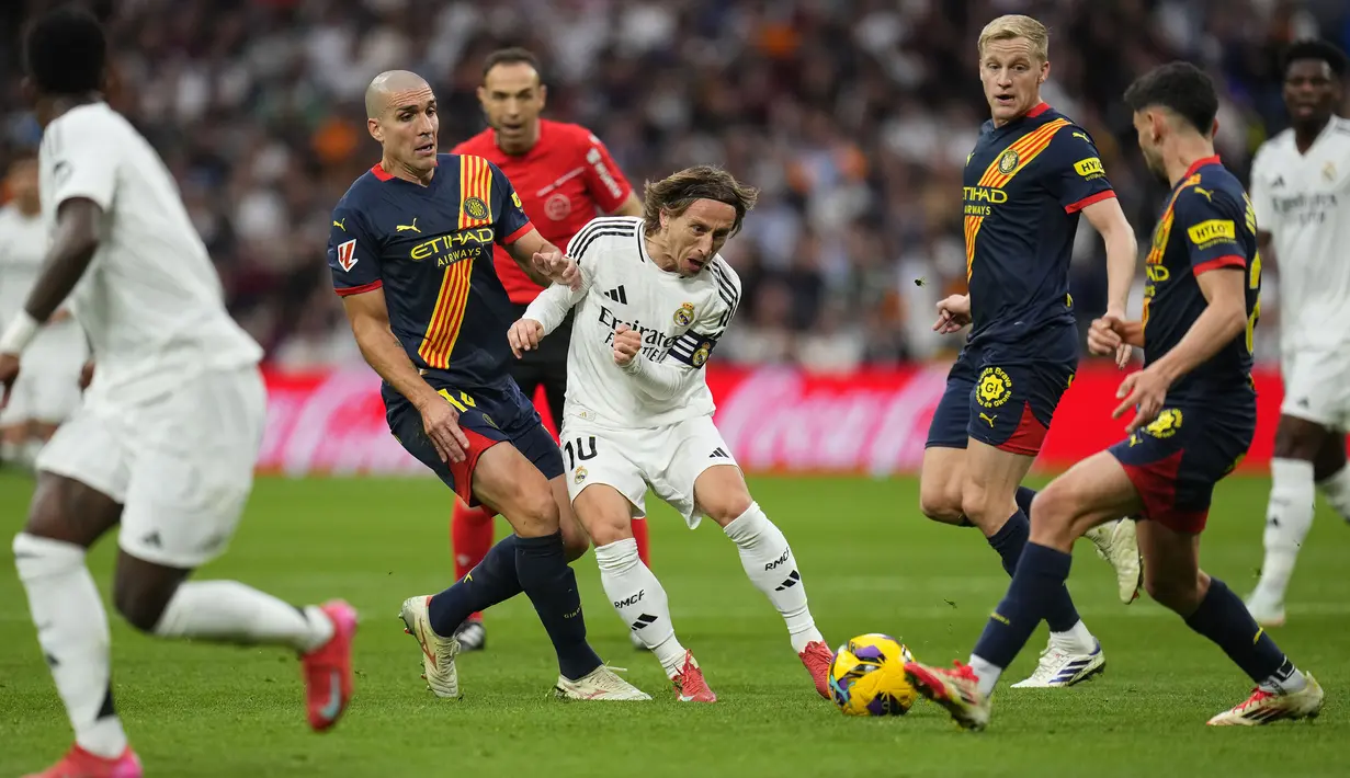 Pemain Real Madrid, Luka Modric berusaha melewati penjagaan sejumlah pemain Girona dalam laga lanjutan Liga Spanyol 2024/2025 di Stadion Santiago Bernabeu, Madrid, Minggu (24/02/2025) waktu setempat. (AP Photo/Manu Fernandez)