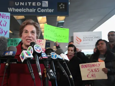 Perwakilan demonstran menyampaikan orasinya di depan terminal United Airlines terkait pengusiran penumpang di pesawat United Airlines di Bandara Internasional O'Hare, Chicago, AS, Selasa (11/4). (Scott Olson / Getty Images / AFP)