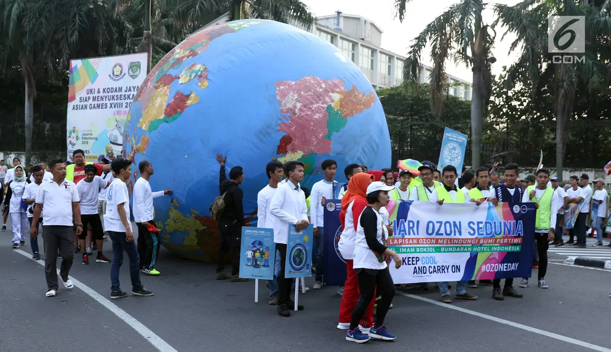 Replika bola dunia berukuran besar digelindingkan di sekitar kawasan Bundaran HI, Jakarta, Minggu (16/9). Acara ini bagian dari peringatan Hari Ozon Sedunia 2018 dengan tema Keep Cool and Carry on! The Montreal Protocol. (Liputan6.com/Helmi Fithriansyah)