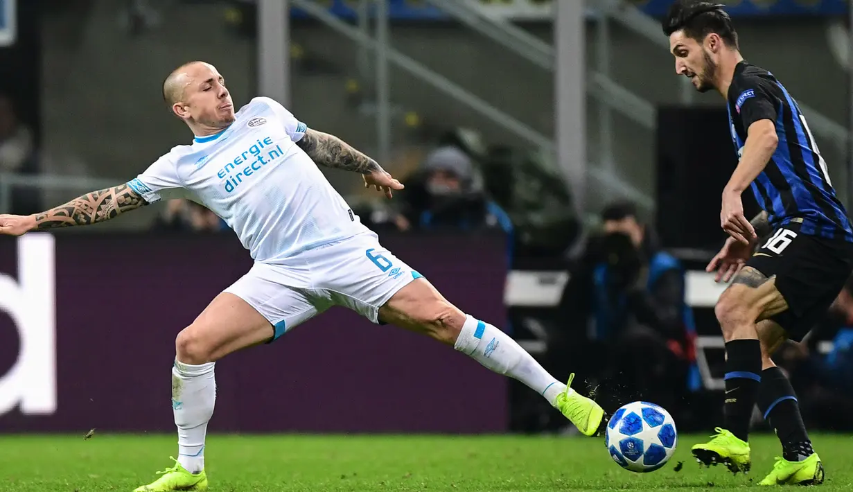 Pemain PSV Eindhoven, Angelino dan gelandang Inter Milan, Matteo Politano berebut bola pada laga pamungkas penyisihan Grup B Liga Champions di Stadion San Siro, Rabu (12/12). Inter terdepak dari Liga Champions setelah bermain 1-1. (Miguel MEDINA / AFP)
