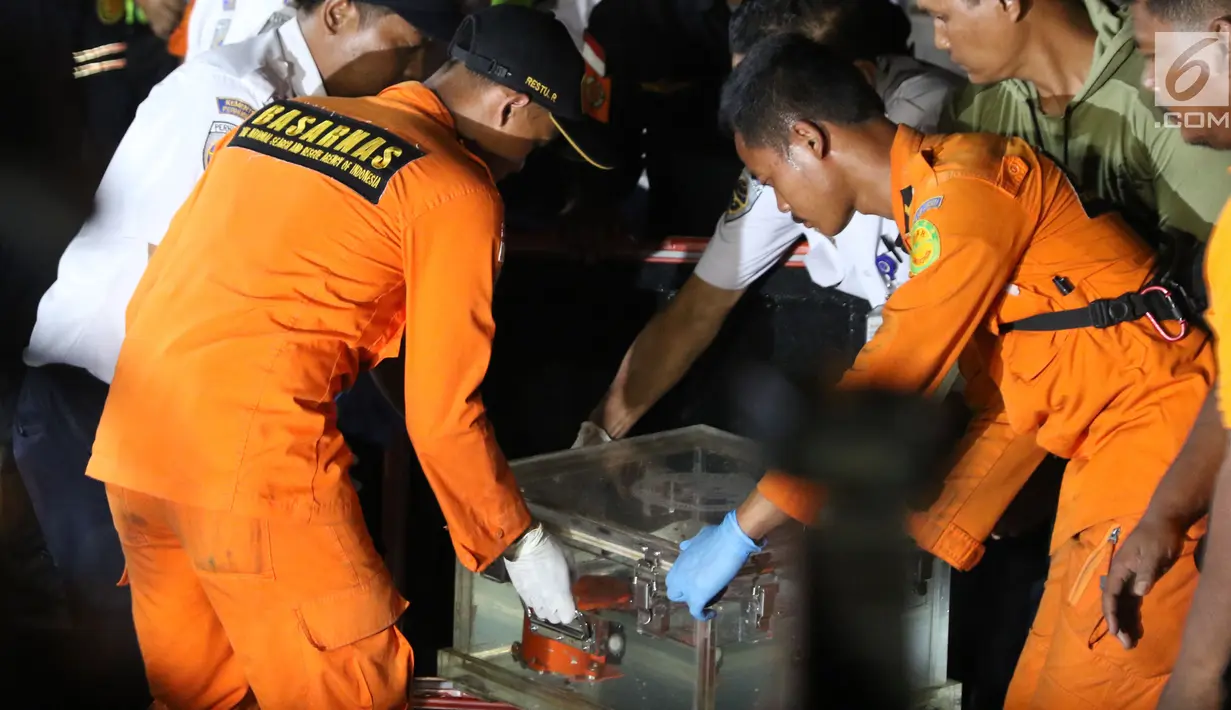 Petugas Basarnas membawa Black Box atau kotak hitam pesawat Lion Air JT 610 di posko evakuasi JICT 2, Tanjung Priok, Jakarta, Kamis (1/11).  Benda bewarna oranye tersebut diduga kuat merupakan FDR Black Box Lion Air. (Liputan6.com/Helmi Fitriansyah)