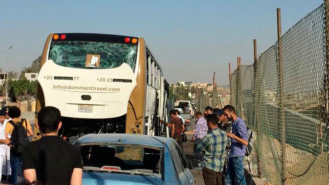 Bus wisata dan mobil yang rusak setelah ledakan bom terparkir di pinggir jalan dekat Piramida Giza, Kairo, Minggu (19/5/2019). Menurut sumber keamanan, para korban luka kebanyakan dikarenakan akibat terkena pecahan kaca. (AP Photo/Mohammed Salah)