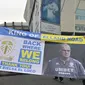 Pendukung Leeds United mengangkat spanduk besar saat mereka berkumpul di luar tanah Elland Road mereka untuk merayakan kembalinya klub ke Liga Premier setelah  16 tahun, di Leeds, Inggris utara (17/7/2020). (AFP/Paul Ellis)