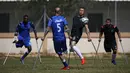 Seorang pemain klub Al-Jazeera (hitam) mengontrol bola dalam pertandingan final kejuaraan lokal sepak bola korban amputasi melawan Al-Abtal yang diselenggarakan oleh Komite Palang Merah Internasional (ICRC), di tengah pandemi COVID-19, di Kota Gaza, Palestina, (18/3/2021). (AFP/Mohammed Abed)