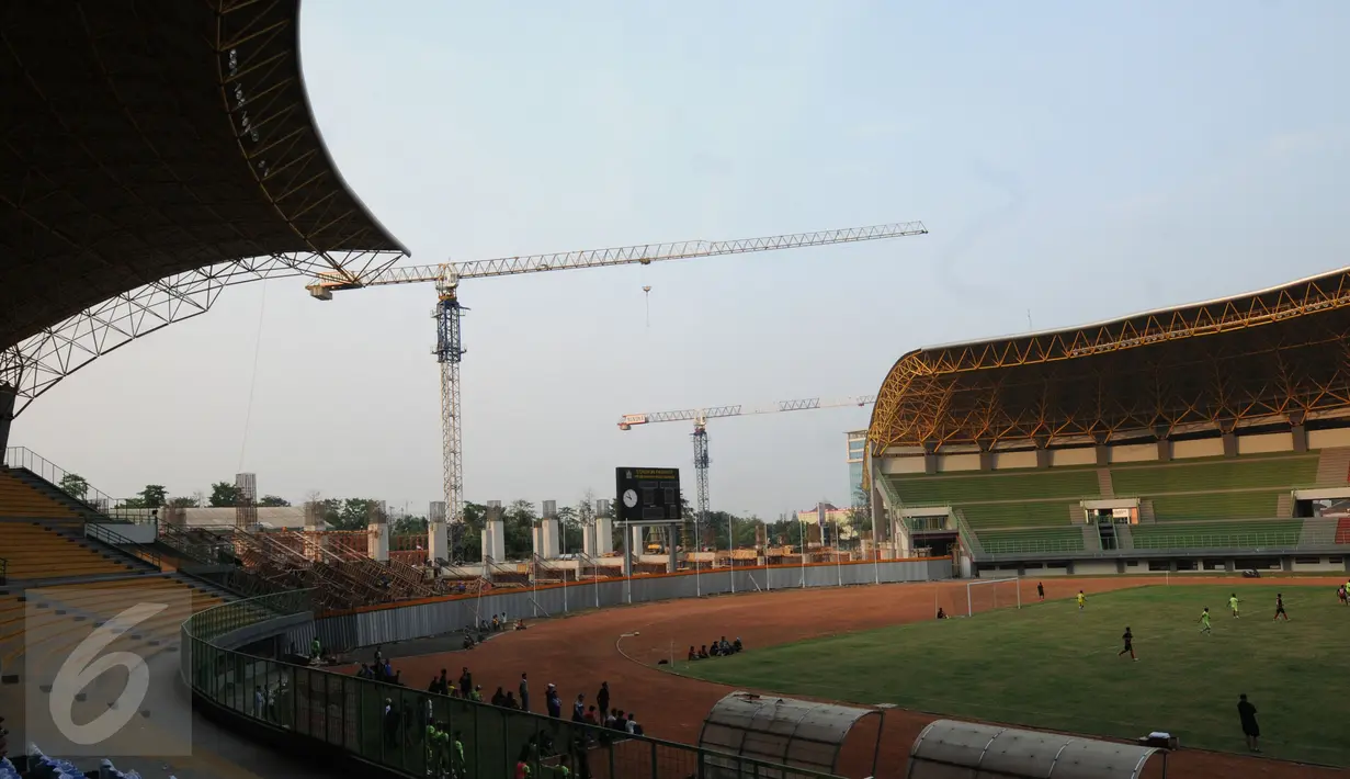 Alat berat terpasang di sisi Utara Stadion Patriot Bekasi, Selasa (25/8/2015). Sejak 23 April 2015 lalu, pembangunan Stadion Patriot kembali dilanjutkan dan diharapkan rampung sebelum pelaksanaan PON, September 2016. (Liputan6.com/Helmi Fithriansyah)