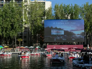 Orang-orang di atas kapal menghadiri Cinema on the Water, yang diselenggarakan Paris Plages selama pemutaran "Le Grand Bain" di Paris, Prancis pada 18 Juli 2020. Paris menghadirkan terobosan baru dengan bioskop terapung lengkap dengan perahu yang tetap menjaga jarak. (AP Photo/Rafael Yaghobzadeh)