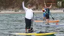 Direktur Utama Ketenagakerjaan, Agus Susanto dan Bupati Trenggalek, Mochammad Nur Arifin olah raga  Stand Up Paddle di Pantai Mutiara, Trenggalek, Jawa Timur, Sabtu (7/9/2019). (Liputan6.com/Herman Zakharia)