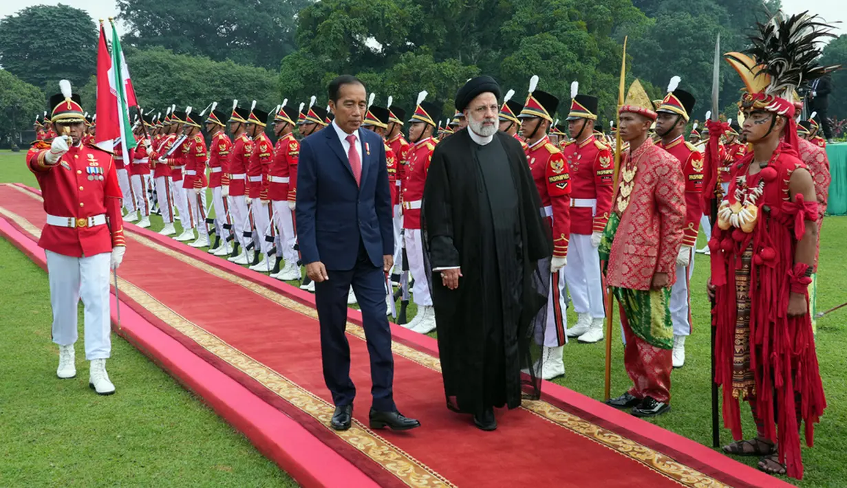 Jokowi mengenakan jas gelap dan dasi warna merah, sementara Ebrahim Raisi mengenakan jubah berwarna hitam. (AP Photo/Achmad Ibrahim)