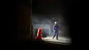 Seorang petugas penyelamat berjalan disamping bangunan garasi parkir bawah tanah yang runtuh di sebuah kompleks di Mexico City (10/4). Akibat insiden tersebut, sejumlah orang tewas dan masih terjebak di dalam. (AP Photo/Rebecca Blackwell)