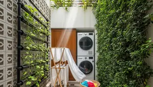 Inspirasi Area Jemuran Belakang Dapur dengan Roster Beton dan Tanaman Vertikal Pipa (Image by Gemini AI)