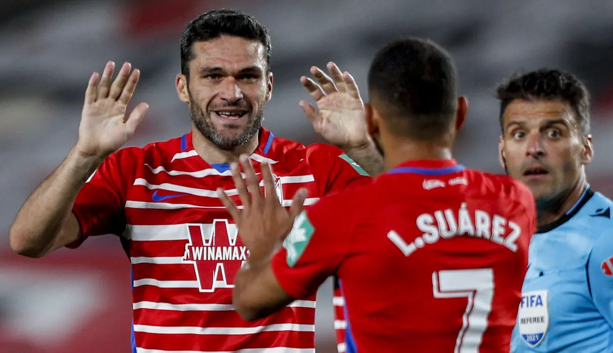 Striker Granada, Jorge Molina (kiri) melakukan selebrasi usai mencetak gol ke gawang Real Madrid dalam laga lanjutan Liga Spanyol 2020/2021 pekan ke-36 di Los Carmenes Stadium, Granada, Kamis (13/5/2021). Granada kalah 1-4 dari Real Madrid. (AP/Fermin Rodriguez)