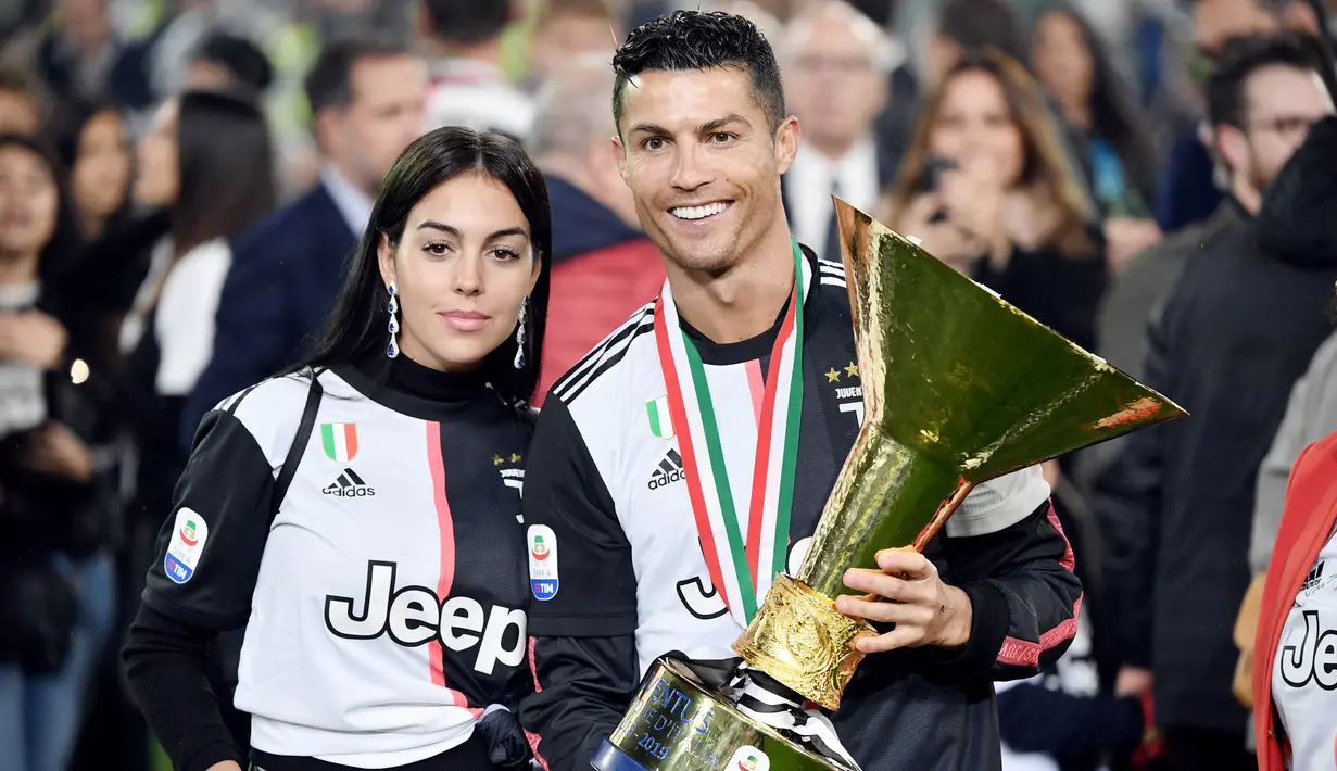 Cristiano Ronaldo bersama kekasihnya, Georgina Rodriguez, berpose dengan trofi Serie A di Stadion Allianz, Turin (19/5/2019). (AFP/Marco Bertorello)