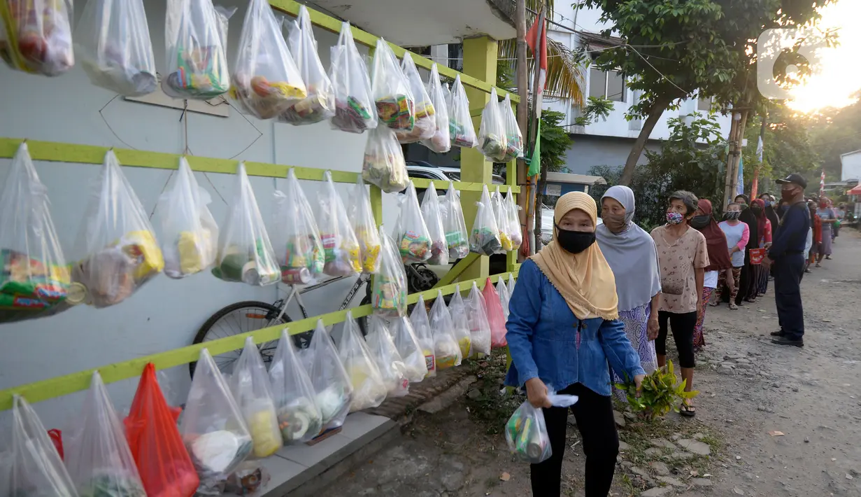 Antrean warga sekitar perumahan Villa Pamulang mengambil paket sembako gratis bernama “Jumat Berkah” yang digantung di Tangerang Selatan, Jumat (28/8/2020). Setiap Jumat selama pandemi, warga perumahan itu mendonasikan sembako untuk warga sekitar yang terdampak COVID-19. (merdeka.com/Dwi Narwoko)