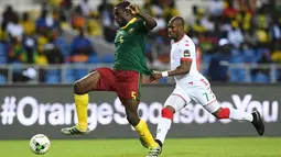 Bek Kamerun, Michael Ngadeu-Ngadjui, berhasil melewati gelandang Burkina Faso, Prejuce Nakoulma. Pada laga ini Kamerun menggunakan formasi 4-2-3-1, sementara Burkina Faso memakai skema 4-4-2. (AFP/Gabriel Bouys)