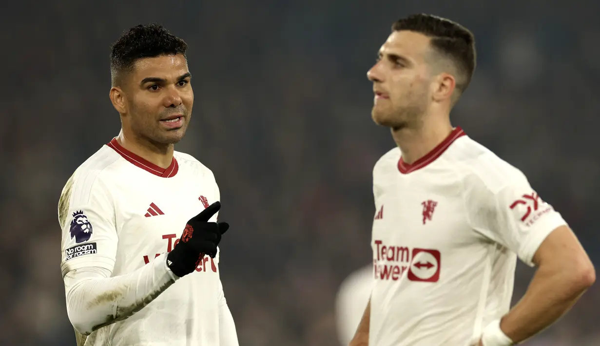 Pemain Manchester United, Casemiro, berbincang dengan Diogo Dalot saat melawan Crystal Palace dalam laga pekan ke-36 Premier League 2023/2024 yang digelar di Selhurst Park, Selasa (7/5/2024). (AP Photo/Ian Walton)