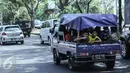 Sejumlah warga menggunakan mobil bak terbuka dengan beratapkan terpal di Jakarta, Minggu (19/7/2015). Meskipun membahayakan, mobil pick up menjadi pilihan warga untuk bersilaturahmi saat momen Lebaran. (Liputan6.com/Faizal Fanani)
