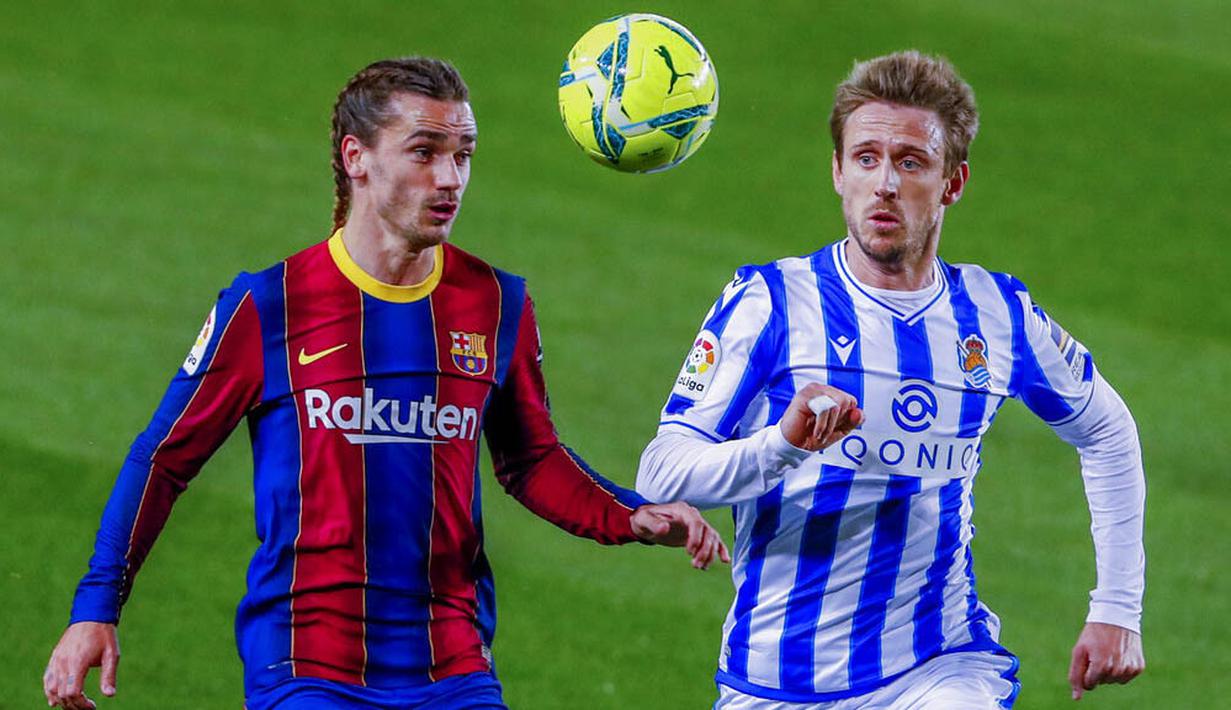 Penyerang Barcelona, Antoine Griezmann, berebut bola dengan pemain Real Sociedad, Nacho Monreal, pada laga Liga Spanyol di Stadion Camp Nou, Kamis (17/12/2020). Barcelona menang dengan skor 2-1. (AP/Joan Monfort)