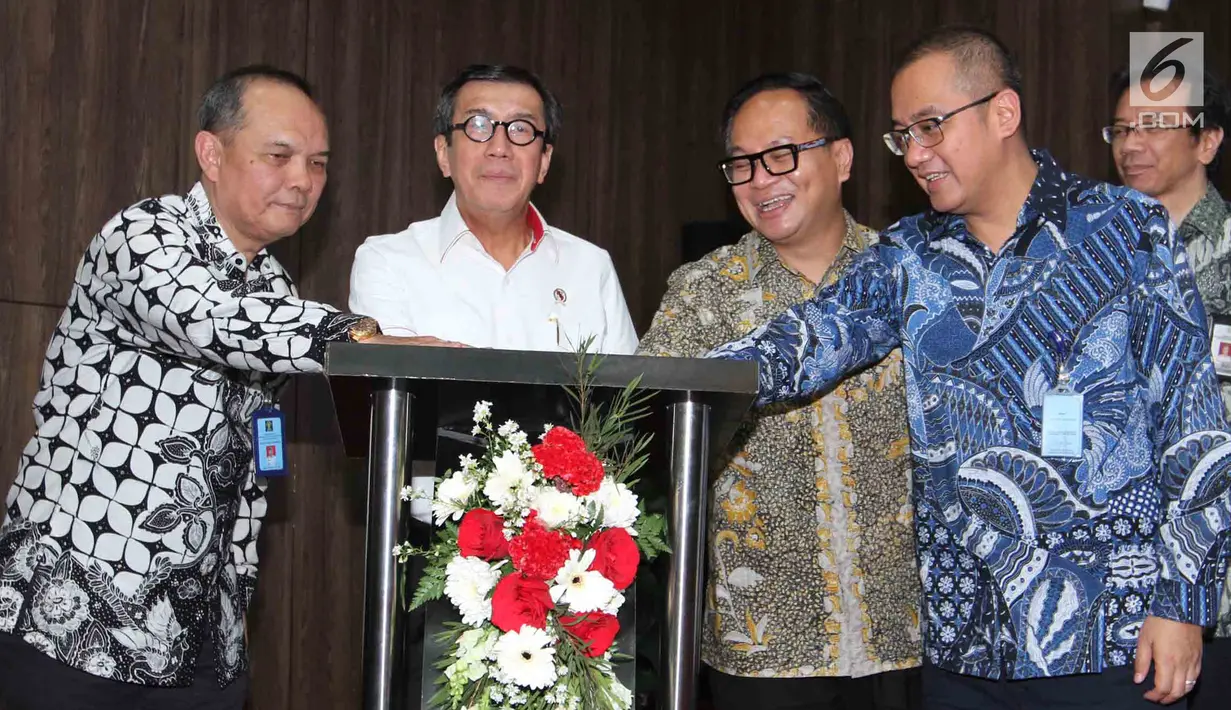 Menkumham Yasonna H. Laoly (kedua kiri) dan Dirut Bank Mandiri Kartika Wirjoatmodjo (ketiga kanan) menekan tombol pada acara kerjasama layanan pembayaran Penerimaan Negara Bukan Pajak (PNBP) secara online/realtime di Jakarta, Kamis (1/8/2019). (Liputan6.com/Angga Yuniar)