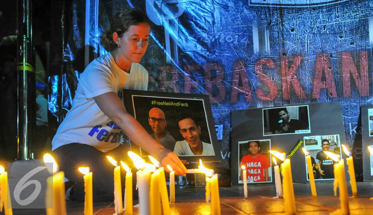 Tracy Bantleman, istri Neil Bantleman guru Jakarta International School (JIS) asal Kanada menyalakan lilin dalam malam Solidaritas kasus JIS di Tugu Proklamasi, Jakarta, Jumat (20/5/2016). (Liputan6.com/Yoppy Renato)
