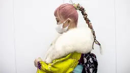 Miu Sakunaga Jepang berusia 20 tahun mengenakan kimono dengan rambut dikuncir berpose di luar Todoroki Arena selama upacara perayaan "Coming-of-Age Day" di Kawasaki, prefektur Kanagawa (11/1/2021). (AFP/Behrouz Mehri)
