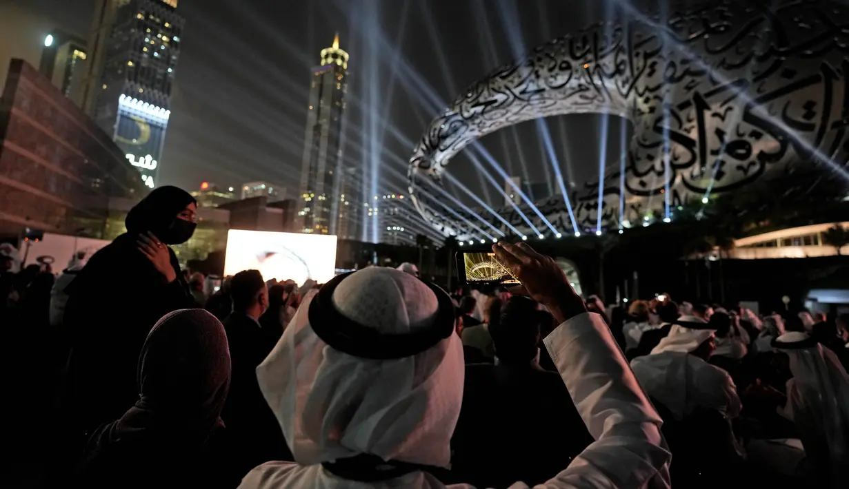 Seorang pria mengambil video dengan ponselnya saat upacara pembukaan Museum of the Future, sebuah ruang pameran untuk ide-ide inovatif dan futuristik, di Dubai, Uni Emirat Arab, Selasa (22/2/2022). (AP Photo/Kamran Jebreili)