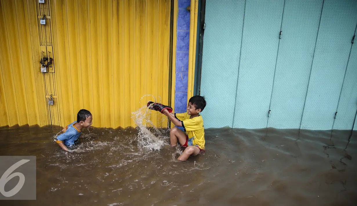 Sejumlah anak-anak manfaatkan genangan banjir untuk bermain di Jalan Gunung Sahari, Jakarta, Kamis (21/4/2016). Hujan yang mengguyur Jakarta sejak tadi malam membuat beberapa ruas jalan Jakarta tergenang banjir. (Liputan6.com/Faizal Fanani)