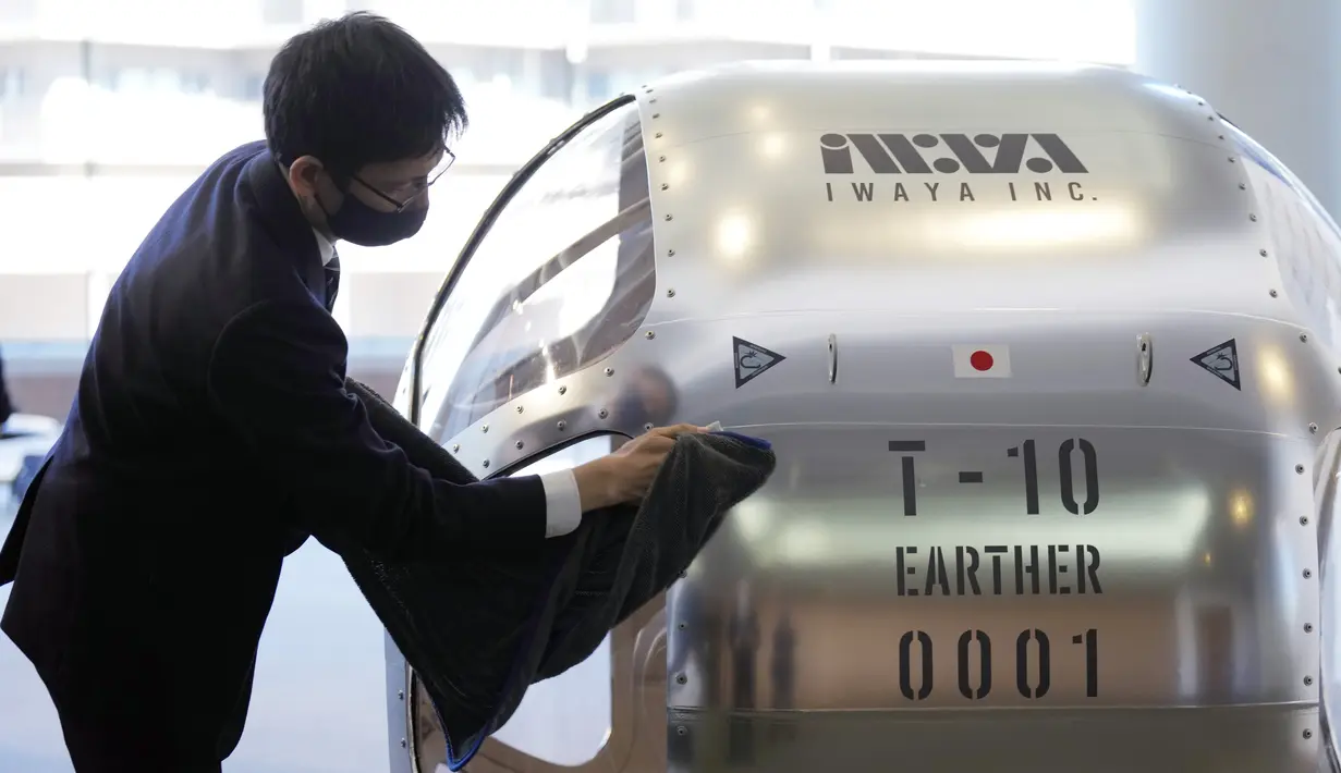 Seorang staf membersihkan kabin dua tempat duduk yang menurut perusahaan rintisan mampu naik hingga ketinggian 15 mil, yang kira-kira berada di tengah stratosfer, saat konferensi pers di Tokyo, Selasa, 21 Februari 2023. Perusahaan startup Jepang mengumumkan rencana Selasa untuk meluncurkan penerbangan balon pengamatan ruang angkasa komersial yang diharapkan akan membawa pengalaman yang sangat mahal ke bumi. (Foto AP/Eugene Hoshiko)