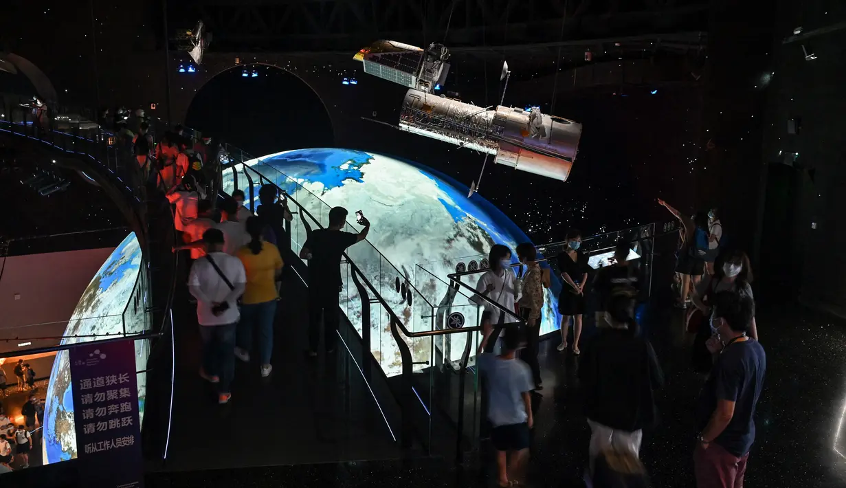 Orang-orang mengunjungi Planetarium Shanghai yang baru dibuka di Shanghai (30/7/2021). Museum Astronomi Shanghai juga menampilkan beberapa teleskop, termasuk sebuah teleskop berdiameter satu meter. (AFP/Hector Retamal)