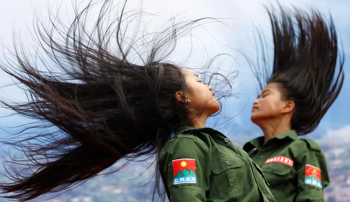 Dua prajurit wanita Tentara Negara Persatuan WA saat menari dalam sebuah acara di Pansang, wilayah pemberontak Wa di Myanmar pada 1 Oktober 2016. Kelompok Wa merupakan pemberontak yang paling kuat di Myanmar. (Reuters/Soe Zeya Tun)