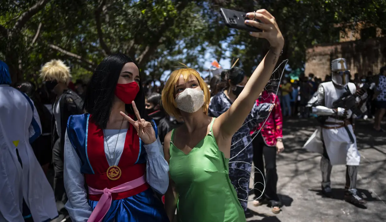 <p>Penggemar anime dan video game Kuba berpakaian seperti pahlawan atau karakter favorit mereka, berpose untuk selfie selama parade Cosplay di sela-sela Pameran Buku Internasional Havana, di Havana, Sabtu (23/4/2022). (AP Photo/ Ramon Espinosa)</p>