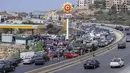 Pemandangan dari sebuah pompa bensin di jalan raya utama saat mobil datang dari segala arah untuk mencoba dan mengisi tangki mereka dengan bensin, di kota pesisir Jiyeh, Jumat (3/9/2021).  Lebanon sedang bergulat dengan krisis ekonomi dan keuangan terburuk dalam sejarah modernnya. (AP/ Hassan Ammar)