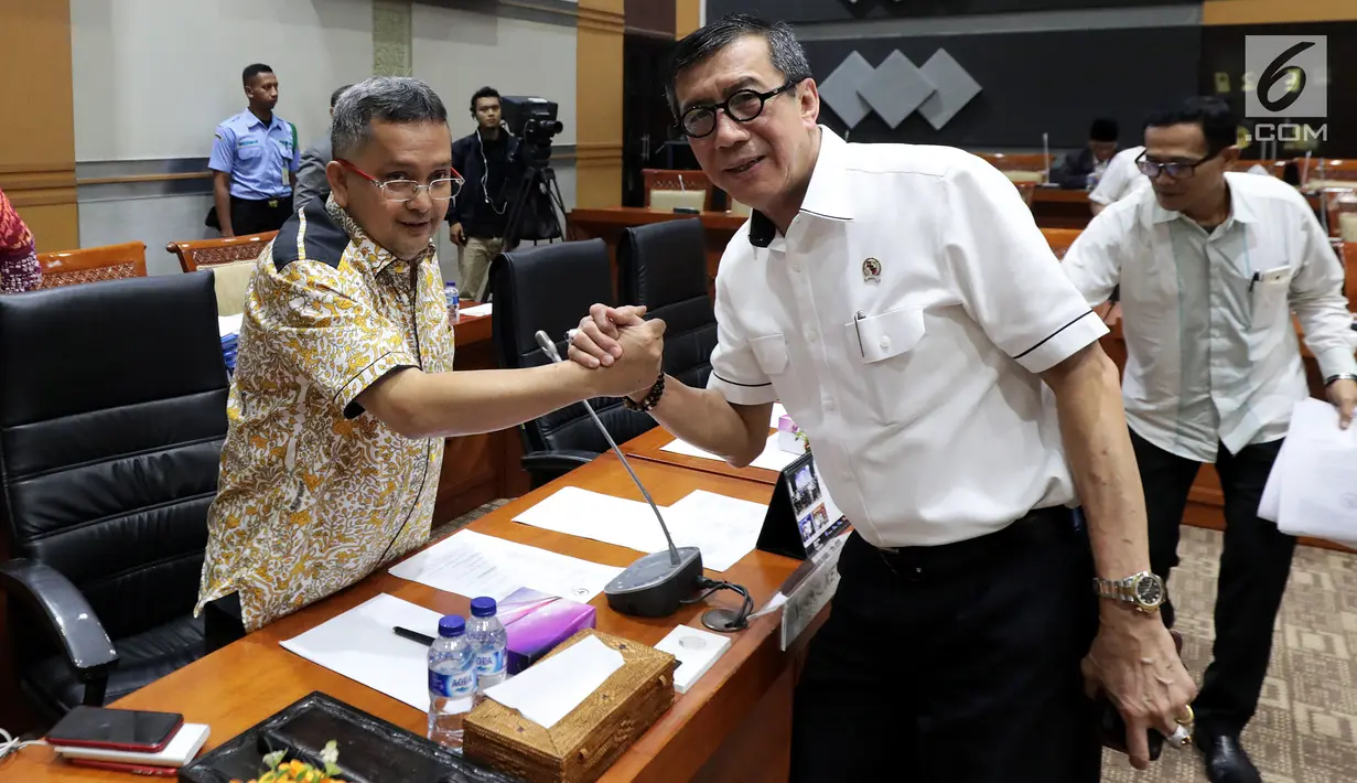 Menteri Hukum dan Hak Asasi Manusia (Menkumham) Yasonna Laoly bersalaman dengan Wakil Ketua Komisi III F-PDIP, Trimedya Pandjaitan saat akan dimulainya rapat kerja di kompleks Parlemen, Jakarta,  Rabu (6/3). (Liputan6.com/Johan Tallo)
