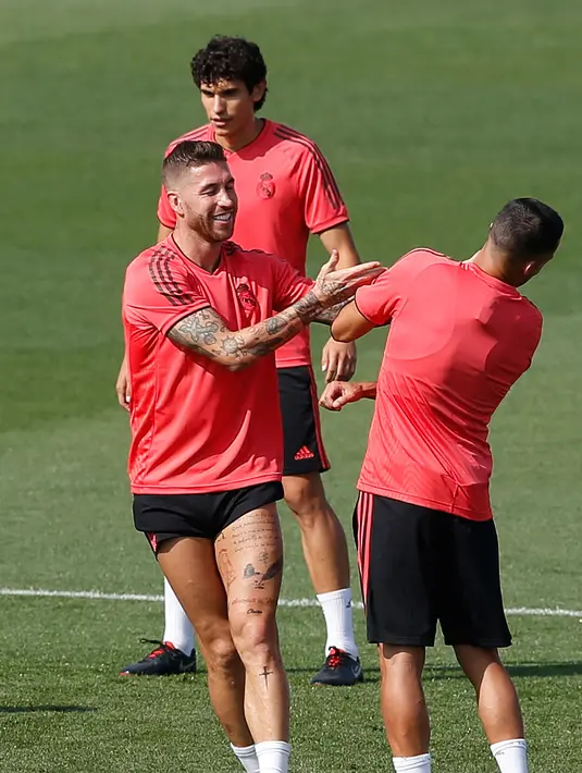 Bek Real Madrid, Sergio Ramos (kiri) bercanda dengan Lucas Vazquez saat berlatih di Madrid, Spanyol, Selasa (18/9). Real Madrid siap menjamu AS Roma pada laga pembuka Grup G Liga Champions. (AP Photo/Paul White)