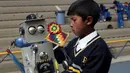 Seorang anak sedang sibuk memasang salah satu bagian kepala robotnya pada olimpiade sains di La Paz, Bolivia,  Senin (10/8/2015).  Acara ini didukung oleh kementrian pendidikan Bolivia dan digelar setiap tahun.  (REUTERS/David Mercado)