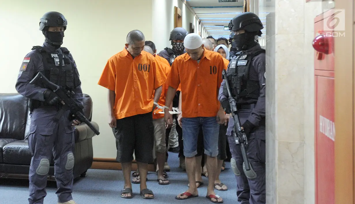 Polisi menggiring tersangka perdagangan manusia (human trafficking) atas korban Enti Sutini di Bareskrim Mabes POLRI, Jakarta (13/9). Modus yang digunakan tersangka adalah memperkerjakan korban sebagai ART dengan data palsu. (Merdeka.com/Arie Basuki)