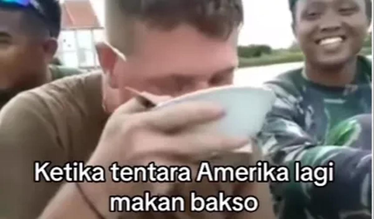 Tak mengerti bahasa yang digunakan kawannya, tentara itu kembali menikmati semangkuk baksonya. Saking lahapnya, dia bahkan tak segan untuk menyeruput kuah bakso di mangkuk.<br>