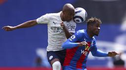 Gelandang Manchester City, Fernandinho (kiri) berebut bola dengan striker Crystal Palace, Wilfried Zaha dalam laga lanjutan Liga Inggris 2020/2021 pekan ke-34 di Selhurst Park, London, Sabtu (1/5/2021). Manchester City menang 2-0 atas Crystal Palace. (AP/Catherine Ivill/Pool)
