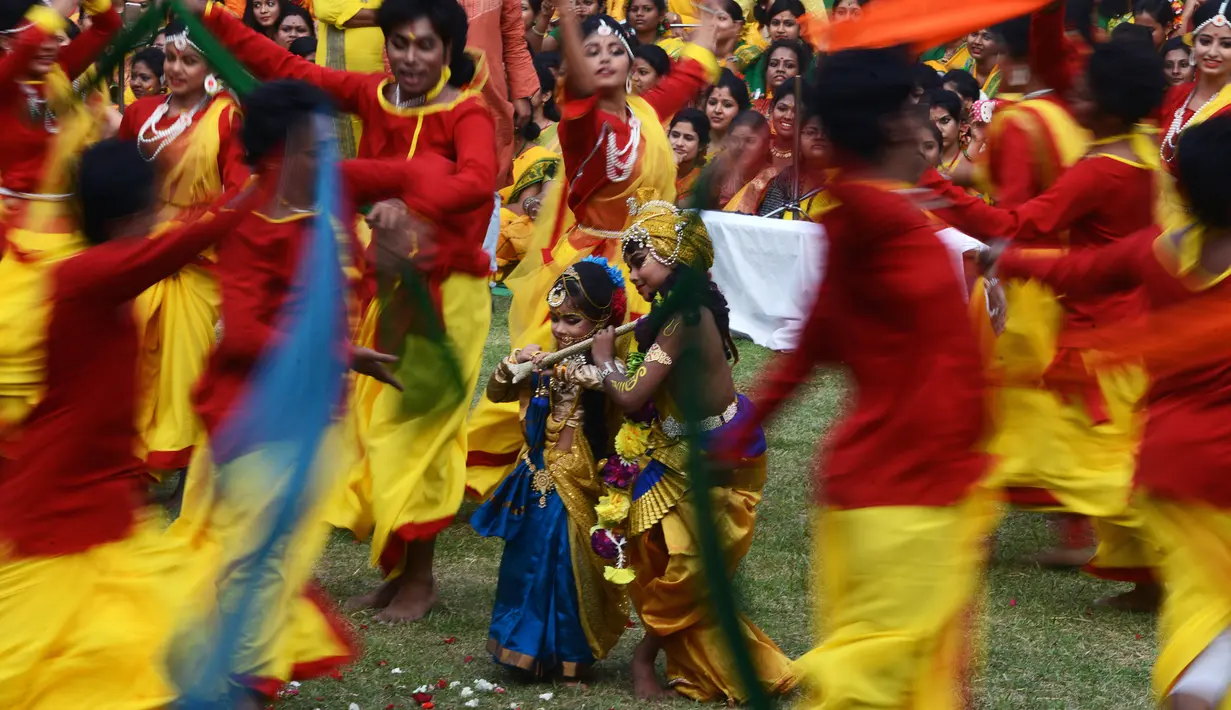 Penampilan sepasang anak-anak selama perayaan Holi di Kolkata, India (7/3). Holi atau Festival Warna adalah festival awal musim semi yang dirayakan di India, Nepal, Bangladesh, dan negara-negara yang mayoritas beragama Hindu. (AFP/Dibyangshu)