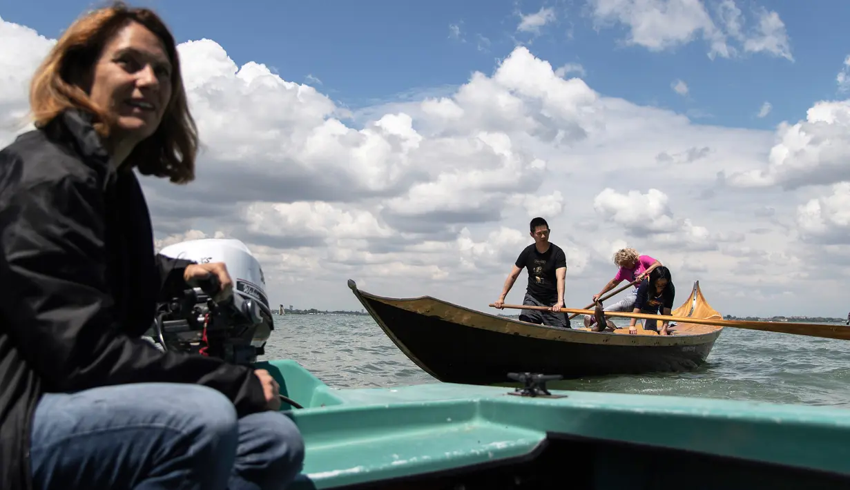 Jane Caporal, anggota Row Venice, mengajarkan mendayung gondola bagi wisatawan di sebuah kanal di Venesia, Italia pada 16 Mei 2019. Pengalaman ini bisa dimiliki dengan €85 atau sekitar Rp 1,37 juta per gondola selama 90 menit untuk empat orang yang dimulai pukul 10.00 pagi. (MARCO BERTORELLO/AFP)