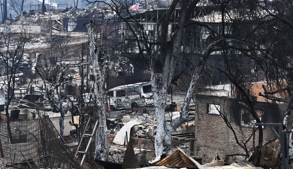 Rumah-rumah dan kendaraan yang terbakar terlihat setelah kebakaran hutan di Quilpue, Vina del Mar, Chili, pada tanggal 4 Februari 2024. (RODRIGO ARANGUA/AFP)