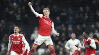 Pemain Arsenal William Saliba, kiri, Pemain Arsenal Martin Odegaard, tengah, Pemain Arsenal Eddie Nketiah, kanan, merayakan kemenangan mereka pada pertandingan sepak bola Liga Inggris antara Tottenham Hotspur dan Arsenal di Stadion Tottenham Hotspur di London, Inggris, Minggu, 15 Januari 2023 (Foto AP/Frank Augstein)