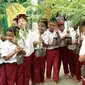 Anak-anak memamerkan bibit pohon yang akan ditanam di pekarang dan kebun orang tua mereka untuk tabungan pendidikan. (Foto: Liputan6.com/Muhamad Ridlo)
