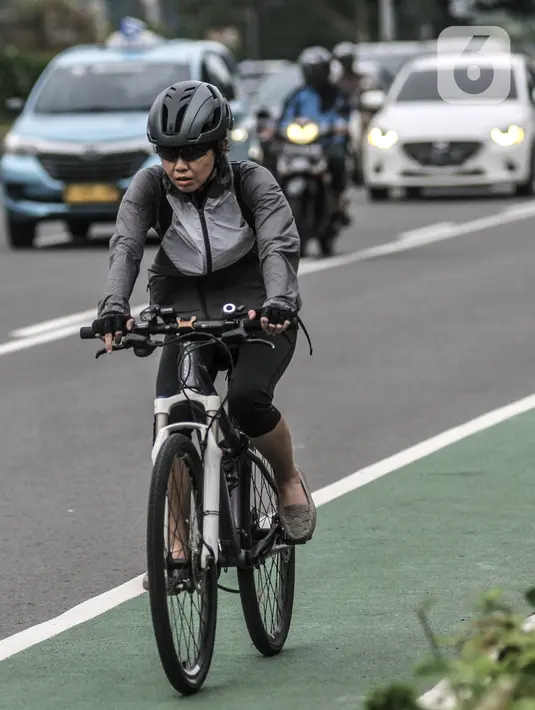 Pesepeda melintasi Jalan Jenderal Sudirman, Jakarta, Senin (18/1/2021). Dinas Perhubungan Provinsi DKI Jakarta mencatat volume lalu lintas pesepeda mengalami peningkatan 4,1 persen selama sepekan pengetatan Pembatasan Sosial Berskala Besar (PSBB). (merdeka.com/Iqbal S. Nugroho)