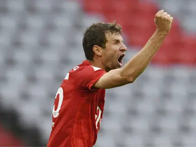 Pemain Bayern Munchen, Thomas Muller, melakukan selebrasi usai membobol gawang Eintracht Frankfurt pada laga Bundesliga di Allianz Arena, Minggu (24/5/2020). Bayern Munchen menang 5-2 atas Eintracht Frankfurt. (AP/Andreas Gebert)