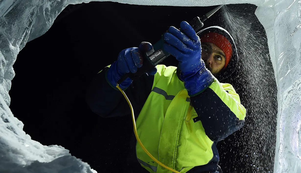 Pemahat es saat membuat salah satu patung sebelum melangsungkan pameran bertema "The Ice Adventure: A Journey Through Frozen Scotland" di Edinburgh, Skotlandia (14/11). (AFP Photo/Andy Buchanan)