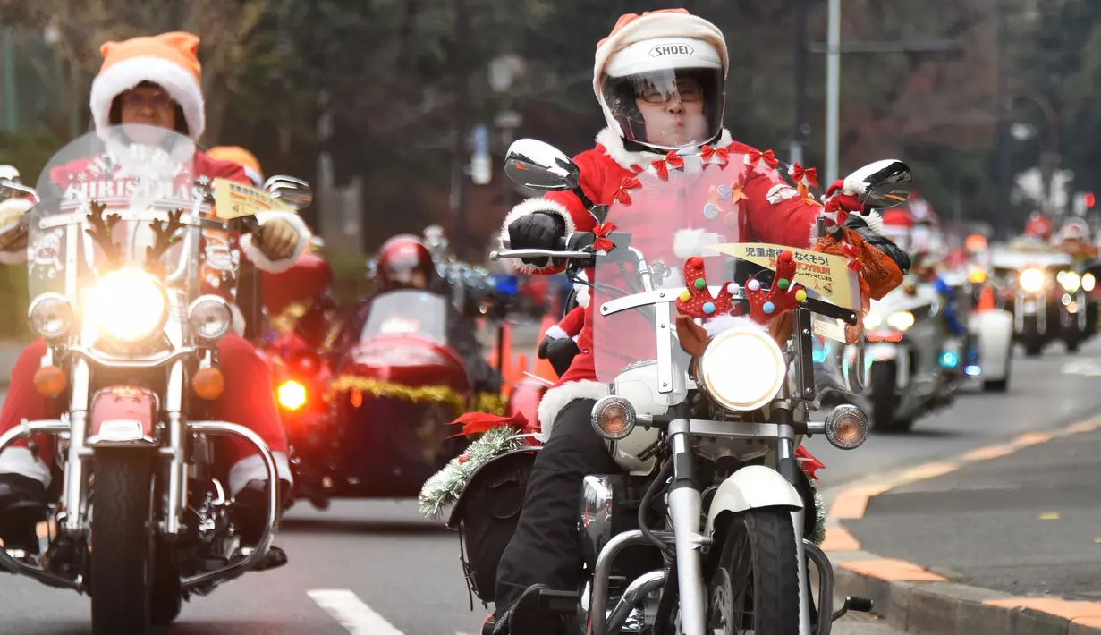 Sejumlah pengendara motor gede mengenakan kostum Santa Claus dan rusa di kota Tokyo, Jepang, (23/12). Sekitar 500 pengendara Harley mengikuti touring ini. (AFP PHOTO/Toru Yamanaka)